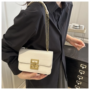 Detail of white crocodile pattern leather crossbody bag with golden chain and lock