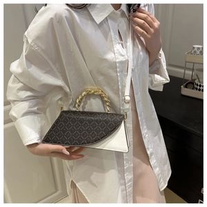 Detail of contrast handbag featuring brown monogram flap and golden knot metal handle