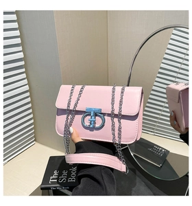 Detail der hellrosa Schultertasche mit silbernem Metalldrehverschluss und Kette