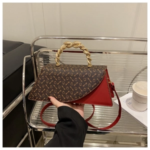 Detail of red and brown leopard flap bag with a golden twisted metal handle