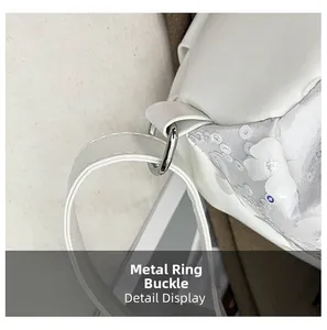 Détail de l'anneau en D argenté et fleur à paillettes sur un sac à main blanc