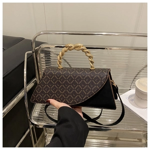 Detail of a leopard print handbag with a vintage gold twisted handle and asymmetric flap