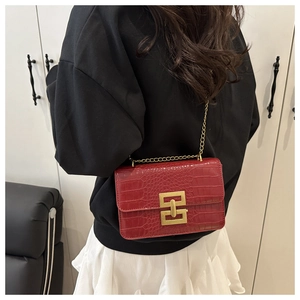 Fashionable red crocodile pattern crossbody bag with gold chain strap on female model