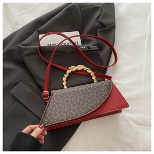 Detail of red leather and brown monogram flap on vintage shoulder bag with gold ring