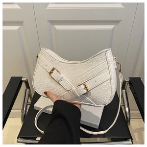 Detail of white crocodile texture crossbody bag with elegant golden buckle straps