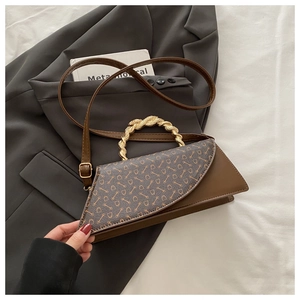 Detail of retro flap bag with gold twisted handle and vintage pattern on grey blazer