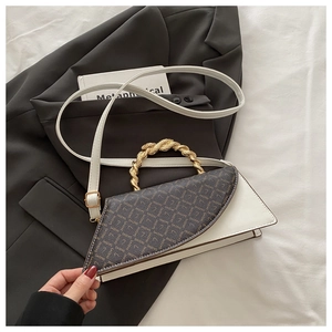 Detail of elegant leopard print flap and spiral gold handle on a white crossbody bag