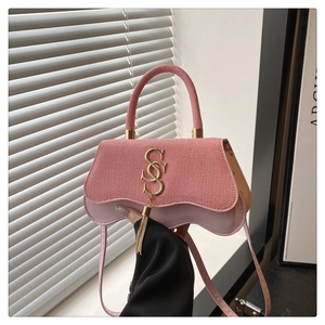 Pink two-tone handbag with woven texture, golden S-buckle, and elegant tassel charm