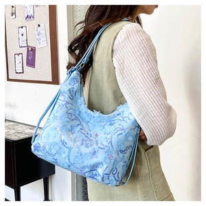 Détail du sac bandoulière bleu clair avec broderie florale 3D et paillettes brillantes