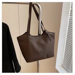 Detail of vintage large tote bag showing textured coffee brown faux leather and thin strap
