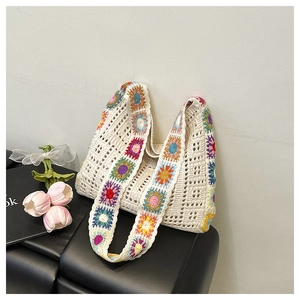 Détail d'un sac cabas au crochet fait main avec motifs floraux colorés granny square