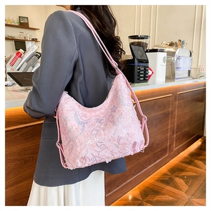 Détail d'un sac bandoulière rose à paillettes avec broderies florales et perles fines