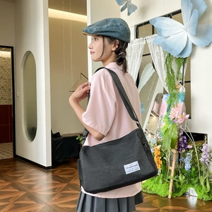 Sac fourre-tout polyvalent en toile noire avec bandoulière et étiquette de marque