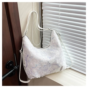Détail de la broderie florale à paillettes blanches et de la bandoulière de ce sac lune
