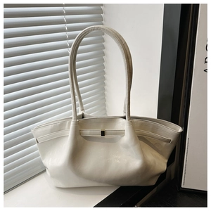 Dettaglio della borsa tote lucida bianca con cinturino in pelle e fibbia dorata