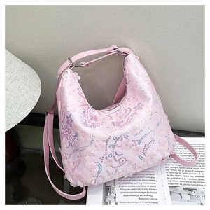 Détail du sac hobo rose avec pétales 3D, paillettes et bandoulière en PU assortie