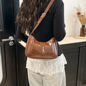 Sac à épaule en cuir verni marron foncé brillant avec boucle en métal et forme en demi-lune