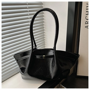 Dettaglio borsa tote in pelle cerata nera con texture vintage e fibbia in metallo