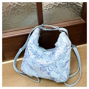 Vue détaillée du sac hobo bleu clair avec appliques florales 3D et paillettes mauves