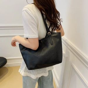 Classic black vintage tote bag in textured leather with adjustable gold hardware