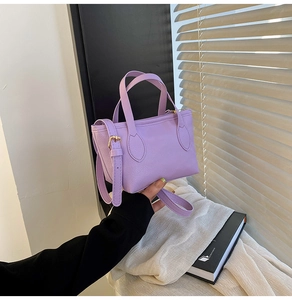 Close-up of lilac lychee grain leather bucket bag with top handles and metal hardware
