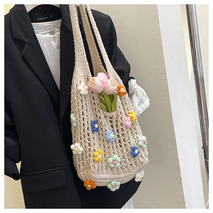 Detail of crochet tote bag with 3D colorful knit flowers and openwork mesh texture