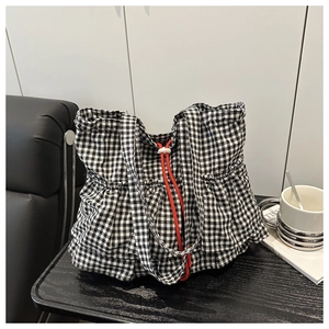 Close-up of gingham tote bag featuring red drawstring closure and elegant ruffle details