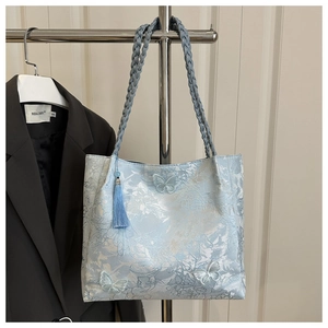 Détail du cabas bleu clair avec broderie papillon 3D et un gland décoratif bleu