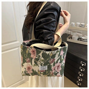 Dettaglio della grande borsa tote in tela con foglie verdi e motivi floreali rosa stampati