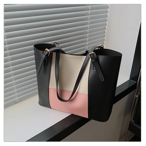 Detailed view of tricolor patchwork tote bag with adjustable gold metal buckle straps