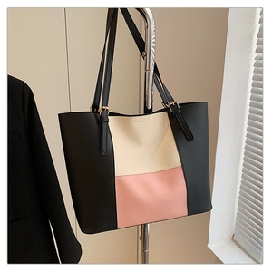 Detailed side view of a large tricolor patchwork tote bag in black beige and pink PU leather