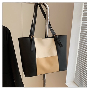 Detailed close-up of a three-color tote bag with adjustable gold buckle handles
