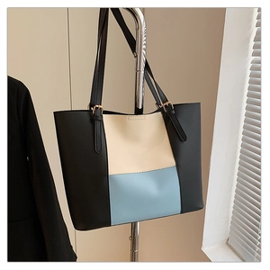 Detail of tricolor拼接 tote bag showing adjustable straps and gold metal hardware