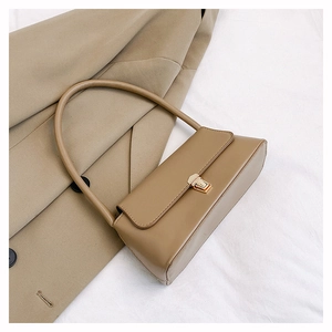 Vue de dessus du sac baguette en cuir kaki avec boucle dorée sur fond de trench-coat