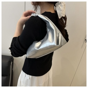 Macro detail of silver crescent hobo bag showing crinkled metallic texture and glossy finish