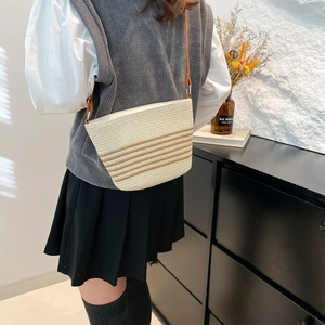 Summer woven straw bucket bag with dark brown stripes and adjustable leather strap