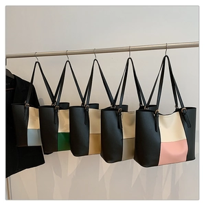 Row of minimalist color-block tote bags hanging on metal rod in different color variations