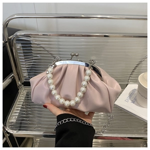 Détail du sac nuage plissé rose avec poignée en perles et bandoulière en chaîne argentée