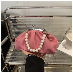 Détail de la pochette rose plissée avec poignée en perles et fermoir métallique