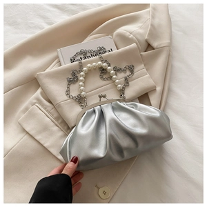 Détail du sac argenté plissé avec poignée en perles élégante et bandoulière en chaîne