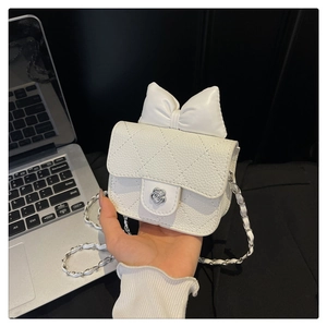 Macro detail of white quilted handbag with camellia clasp and leather chain strap