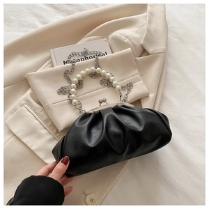 Détail du sac plissé noir avec poignée en perles élégante et chaîne en métal argenté