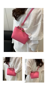 Détail du sac bandoulière en cuir grainé rose avec fermoir rotatif doré et lanière