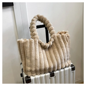 Detailed view of beige plush tote bag featuring bubble handles and vertical stripes