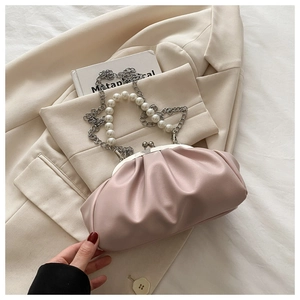 Détail du sac nuage plissé rose poudré avec poignée en perles et bandoulière en chaîne