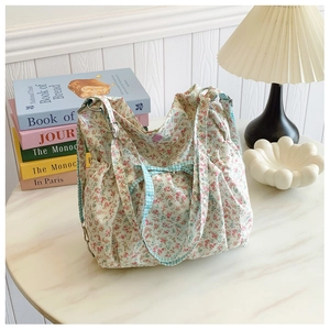 Detail of floral canvas bag featuring blue checkered lining and purple button closure