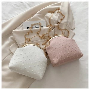 Detalle de bolsos tipo concha con textura 3D punteada y cierres metálicos en tono dorado