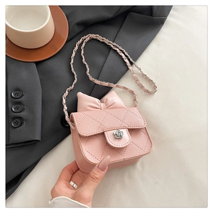 Detail of light pink quilted PU leather mini bag with bow and silver flower clasp