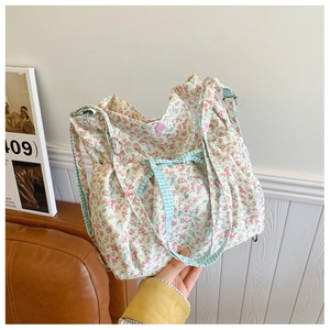 Detail of floral canvas tote bag featuring gingham straps and pink flower pattern