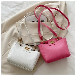 Détail de sacs en cuir grainé avec fermoirs dorés en blanc et rose vif sur blazer